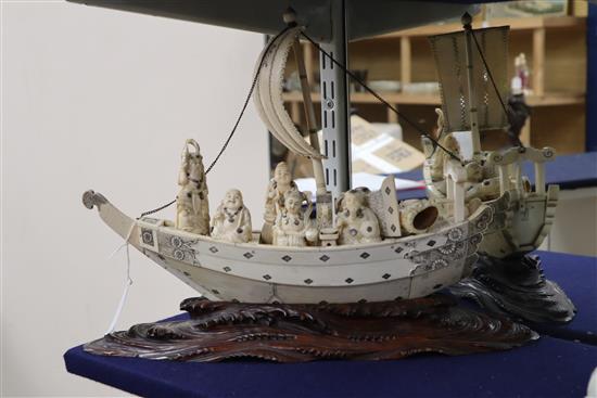 A large Japanese sectional ivory and whale tooth model of the Takarabune, Meiji period, L. 36.5cm, on a wood stand carved as waves